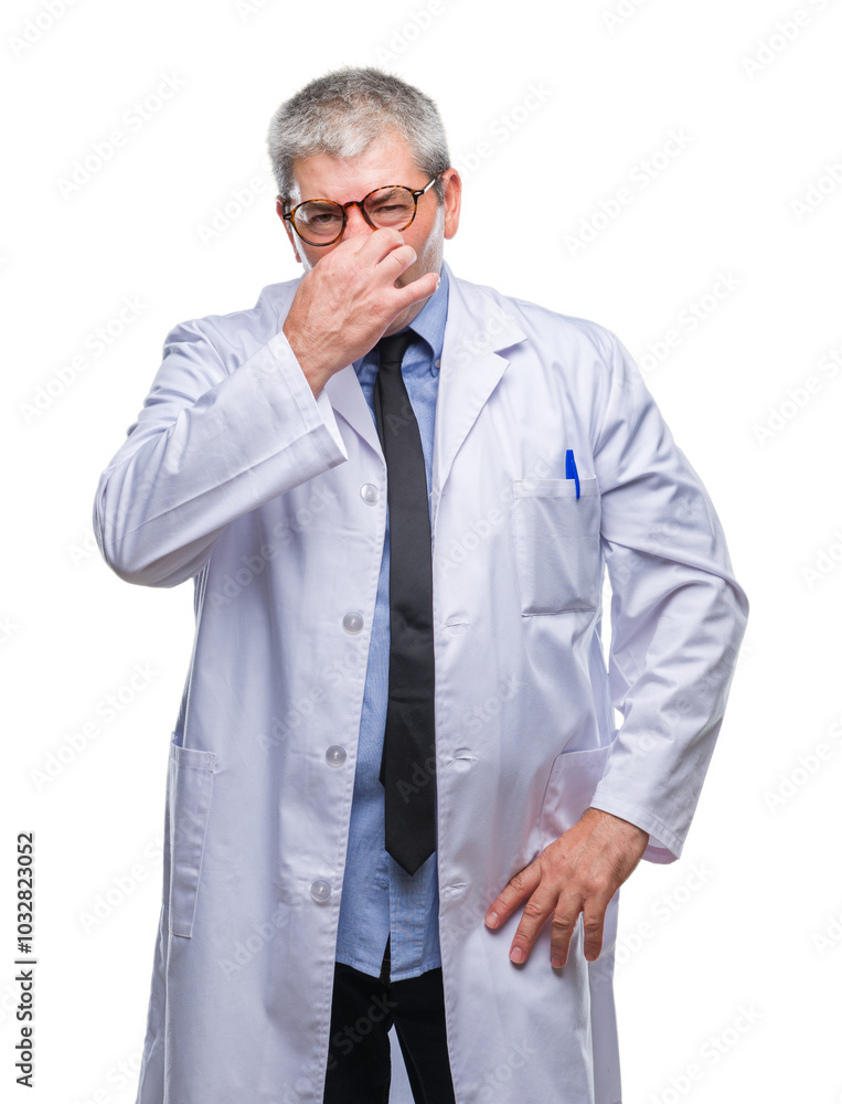 Handsome senior doctor, scientist professional man wearing white coat over isolated background smelling something stinky and disgusting, intolerable smell, holding breath with fingers on nose. Handsome senior doctor, scientist professional man wearing white coat over isolated background smelling something stinky and disgusting, intolerable smell, holding breath with fingers on nose.