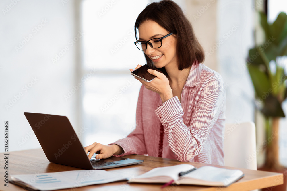 Technology And Communication. Happy businesswoman in glasses using voice command recorder on mobile phone, copyspace Technology And Communication. Happy businesswoman in glasses using voice command recorder on mobile phone, copyspace