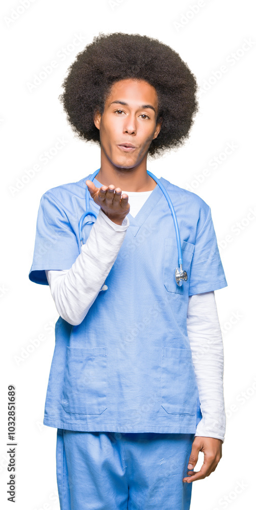 Young african american doctor man with afro hair looking at the camera blowing a kiss with hand on air being lovely and sexy. Love expression. Young african american doctor man with afro hair looking at the camera blowing a kiss with hand on air being lovely and sexy. Love expression.