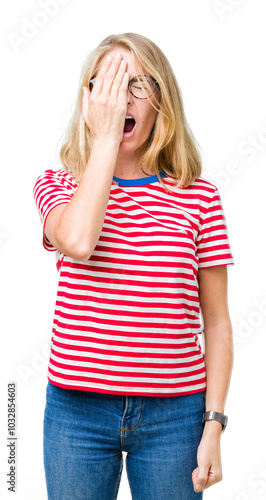 Beautiful young woman wearing glasses over isolated background Yawning tired covering half face, eye and mouth with hand. Face hurts in pain. photo