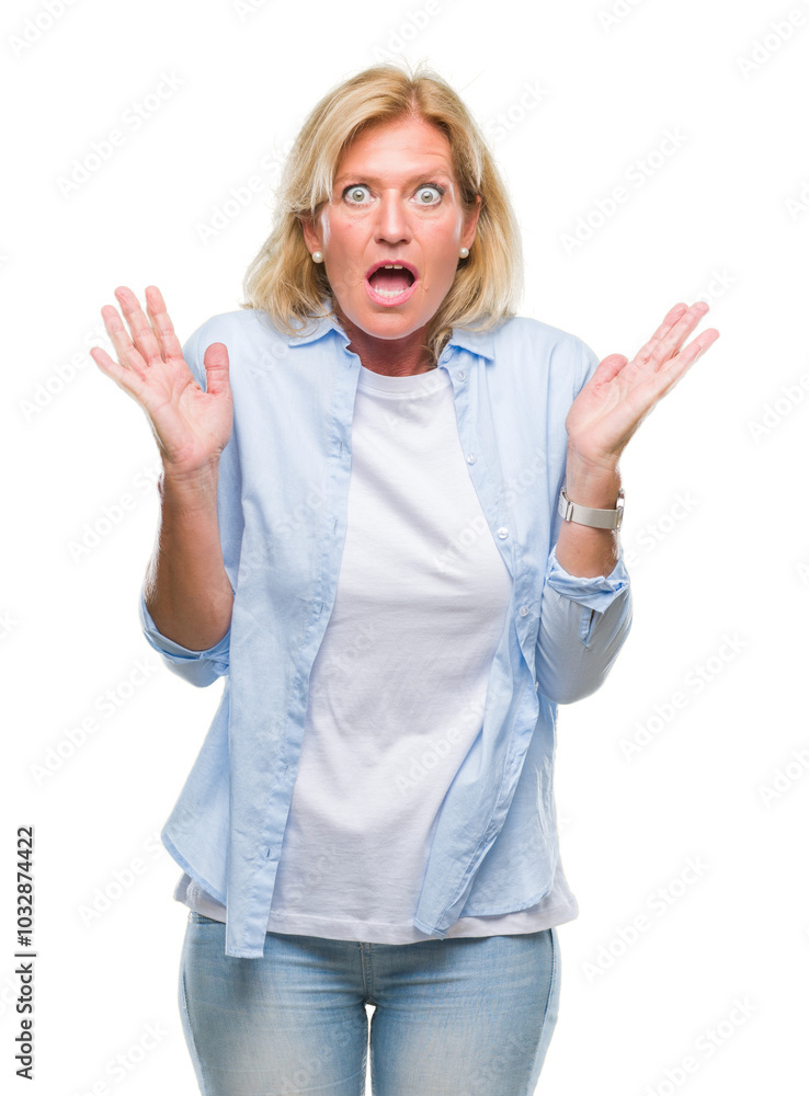 Middle age blonde woman over isolated background afraid and shocked with surprise expression, fear and excited face. Middle age blonde woman over isolated background afraid and shocked with surprise expression, fear and excited face.