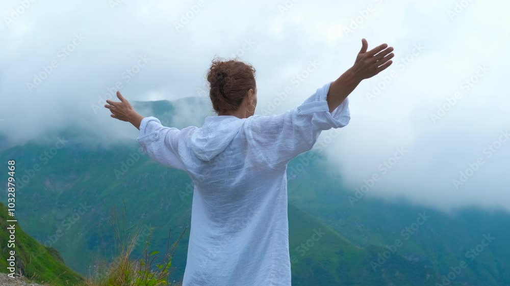 Female against misty hills. A view of female with open hands feel the fresh air against the top of mountains in summer. Female against misty hills. A view of female with open hands feel the fresh air against the top of mountains in summer.