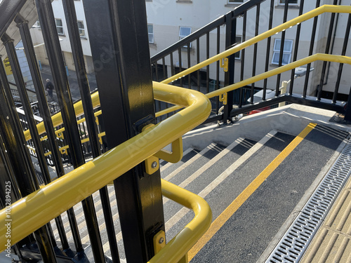 Obraz na płótnie Bright yellow handrails, railings and non-slip stairs on new staircase at railway station w salonie