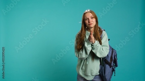 Woman doing begging hand gesture, in ardent need of favor from friend, isolated over studio background. Young girl doing please gesturing, requesting assistance, camera B