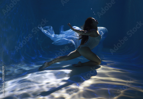 Wallpaper Mural Young sporty woman in white bikini holding blue cloth underwater in the pool Torontodigital.ca