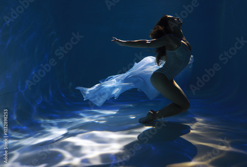 Wallpaper Mural Young sporty woman in white bikini holding blue cloth underwater in the pool Torontodigital.ca