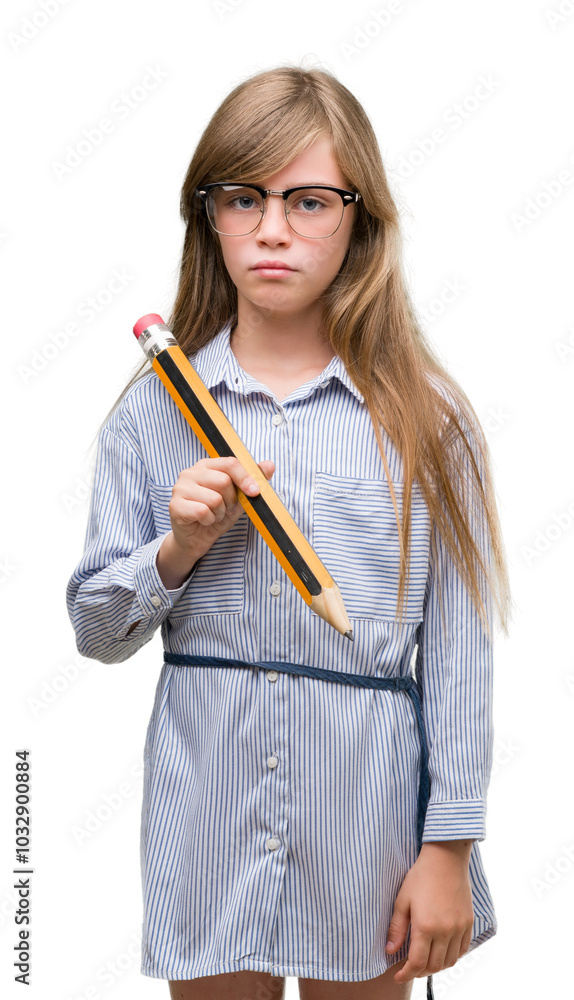 Young blonde child holding big pencil with a confident expression on smart face thinking serious Young blonde child holding big pencil with a confident expression on smart face thinking serious