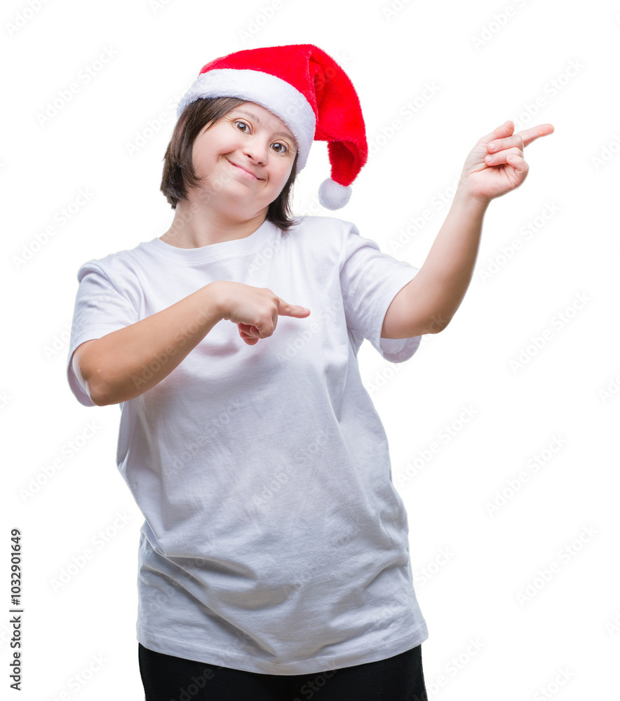 Young adult woman with down syndrome wearing christmas hat over isolated background smiling and looking at the camera pointing with two hands and fingers to the side. Young adult woman with down syndrome wearing christmas hat over isolated background smiling and looking at the camera pointing with two hands and fingers to the side.