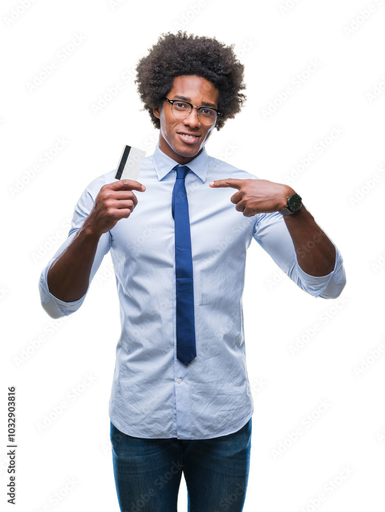 Afro american man holding credit card over isolated background with surprise face pointing finger to himself Afro american man holding credit card over isolated background with surprise face pointing finger to himself
