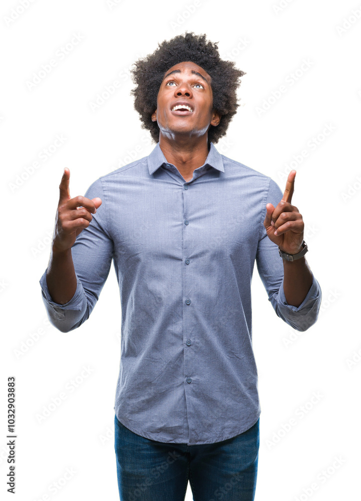 Afro american man over isolated background amazed and surprised looking up and pointing with fingers and raised arms. Afro american man over isolated background amazed and surprised looking up and pointing with fingers and raised arms.