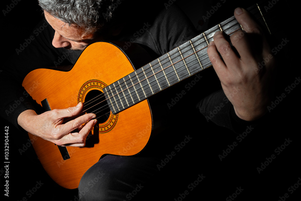 Fototapeta premium CLOSE UP OF A MAN PLAYING CLASSICAL GUITAR.