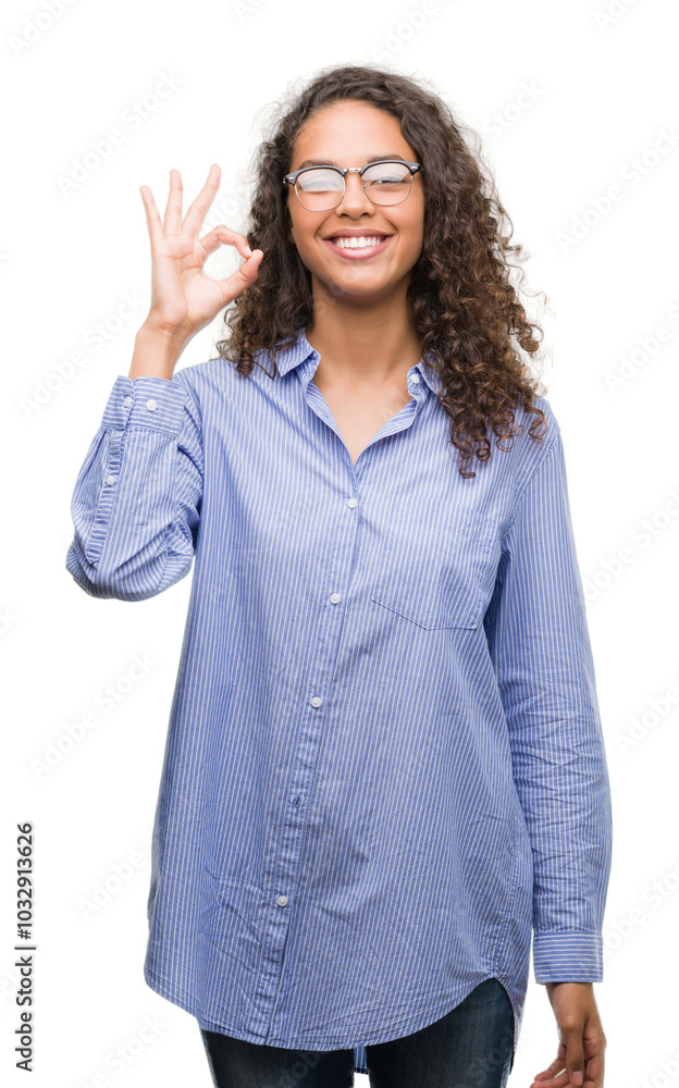 Beautiful young hispanic woman wearing glasses doing ok sign with fingers, excellent symbol Beautiful young hispanic woman wearing glasses doing ok sign with fingers, excellent symbol