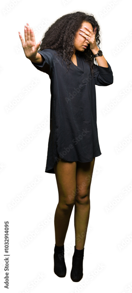 Young beautiful girl with curly hair wearing elegant dress covering eyes with hands and doing stop gesture with sad and fear expression. Embarrassed and negative concept. Young beautiful girl with curly hair wearing elegant dress covering eyes with hands and doing stop gesture with sad and fear expression. Embarrassed and negative concept.
