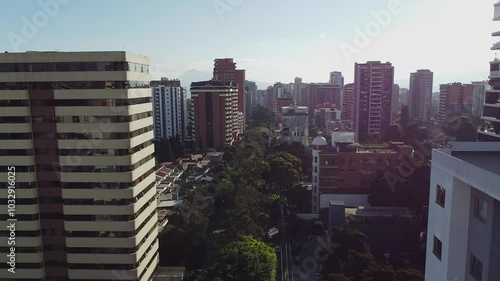 Drone flying between buildings on a cloudy day in Guatemala City, Central America