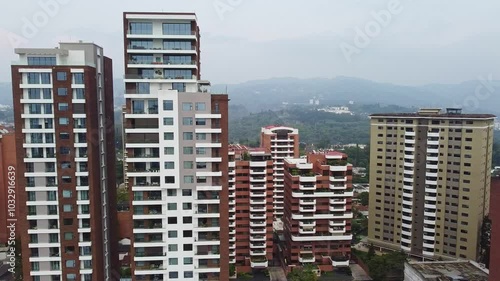 Drone flying between buildings on a cloudy day in Guatemala City, Central America