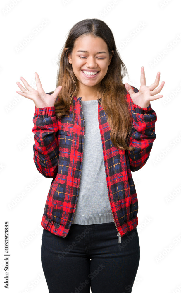 Young beautiful brunette woman wearing a jacket over isolated background celebrating mad and crazy for success with arms raised and closed eyes screaming excited. Winner concept Young beautiful brunette woman wearing a jacket over isolated background celebrating mad and crazy for success with arms raised and closed eyes screaming excited. Winner concept