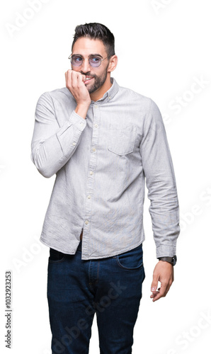 Young handsome man wearing sunglasses over isolated background looking stressed and nervous with hands on mouth biting nails. Anxiety problem. photo