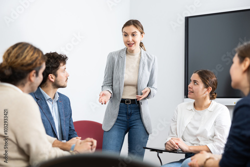 Canvas-taulu Young female professor explaining subject to classroom full of students