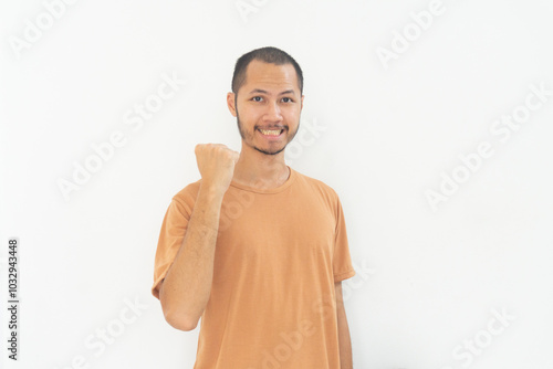 Young  men wearing orange shirt is celebrate with smile on isolated white background photo