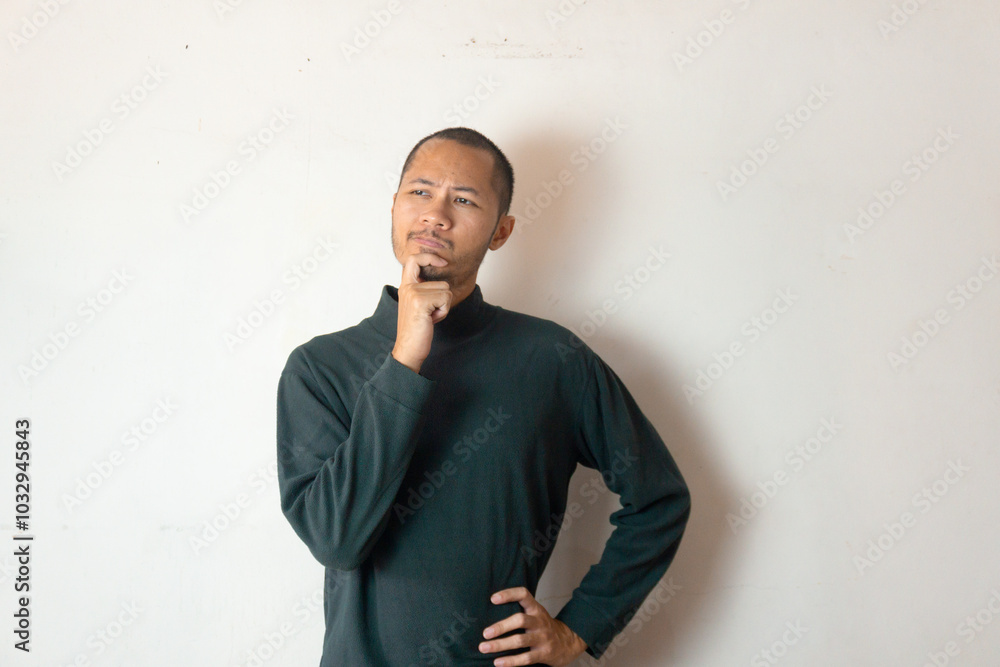 Young men wearing warm clothes is thingking something on isolated white background Young men wearing warm clothes is thingking something on isolated white background