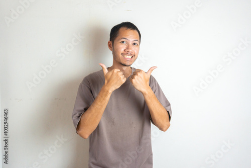 Young men wearing purple shirt smiling with thumbs up on isolated white background photo