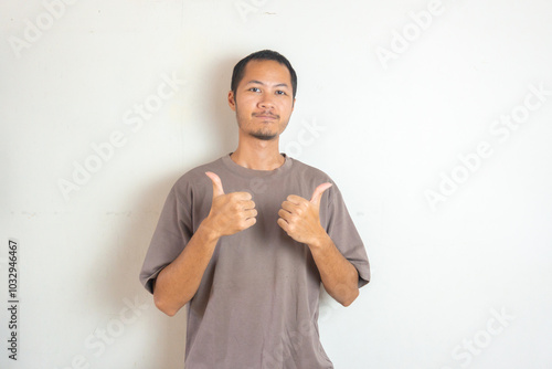 Young men wearing purple shirt smiling with thumbs up on isolated white background photo