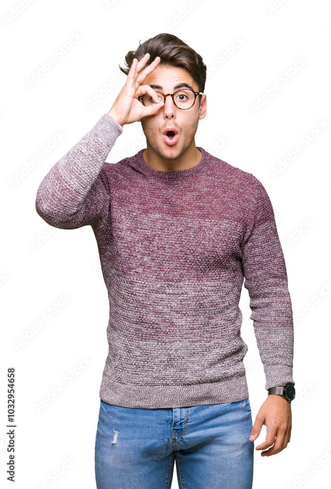Fototapeta premium Young handsome man wearing glasses over isolated background doing ok gesture shocked with surprised face, eye looking through fingers. Unbelieving expression.