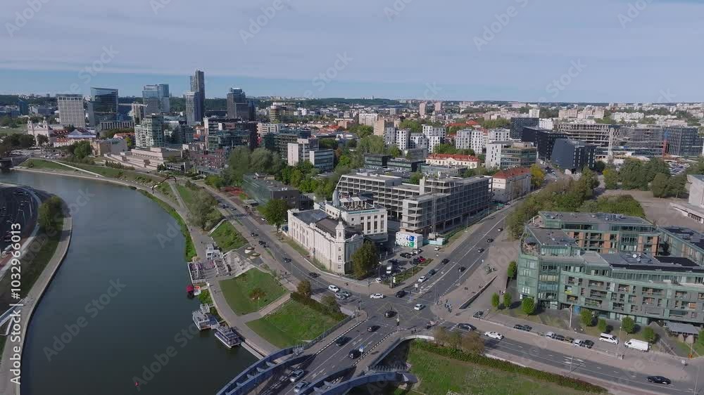 Aerial view of Vilnius, Lithuania, highlighting modern architecture, the Neris River, and lush greenery amidst urban development. Aerial view of Vilnius, Lithuania, highlighting modern architecture, the Neris River, and lush greenery amidst urban development.