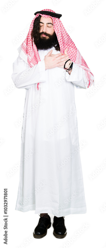 Arabian business man with long hair wearing traditional keffiyeh scarf smiling with hands on chest with closed eyes and grateful gesture on face. Health concept. Arabian business man with long hair wearing traditional keffiyeh scarf smiling with hands on chest with closed eyes and grateful gesture on face. Health concept.