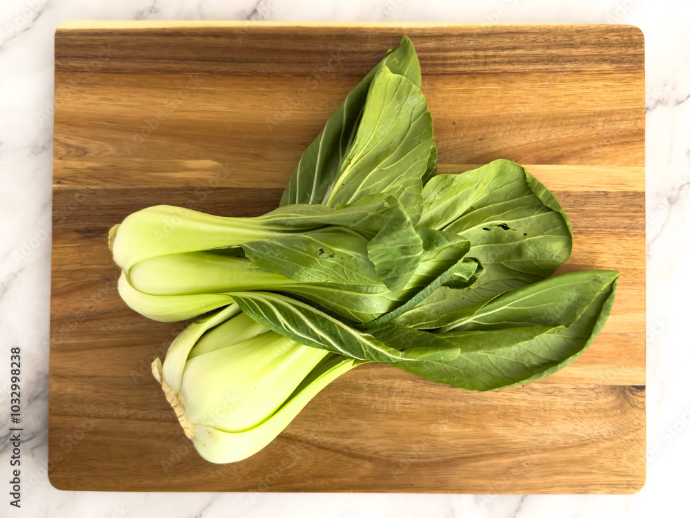 Organic Baby Bok Choy on a cutting board shot from above Organic Baby Bok Choy on a cutting board shot from above
