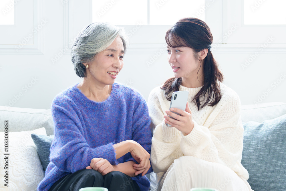 Fototapeta premium おばあちゃんにスマートフォンを教える孫娘