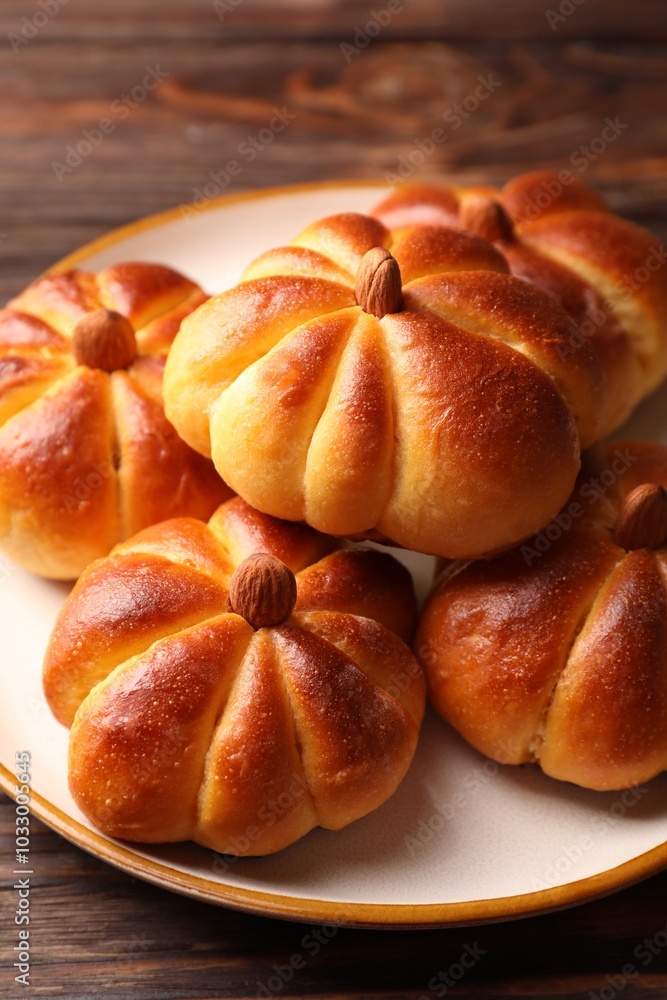 Tasty pumpkin shaped buns on wooden table, closeup Tasty pumpkin shaped buns on wooden table, closeup