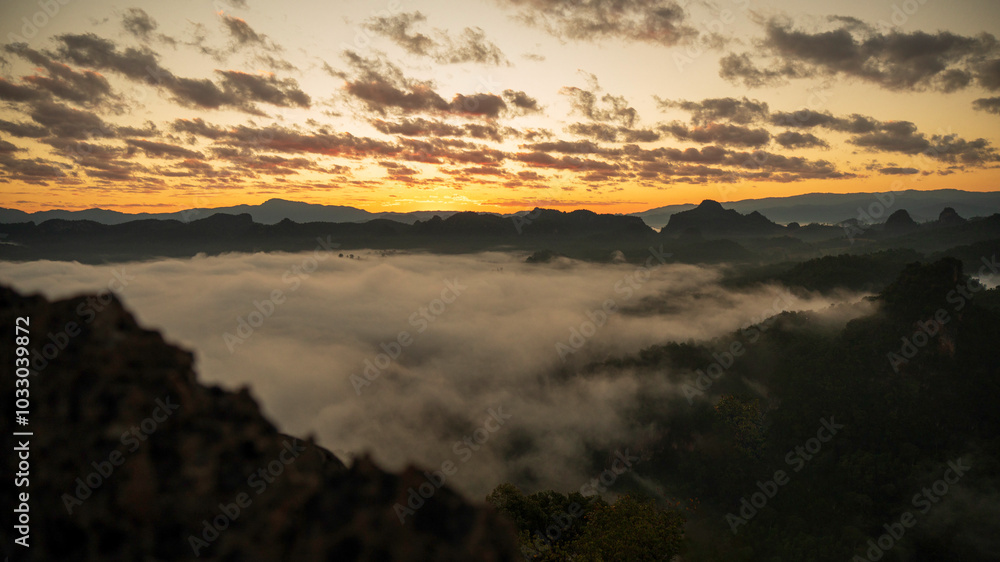 Fototapeta premium Sunset mountain range beautiful landscape mist foggy sunrise beam. Golden sky Mountain landscape foggy windy mountain. Amazing Landscape cloud sky on sunrise. Countryside gold sunlight heaven scene