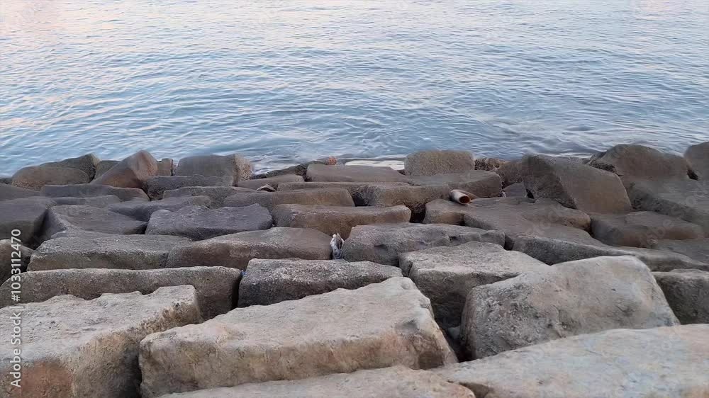 Sea ​​Water With Calm Waves And A Stretch Of Sea Wall Made Of Stone