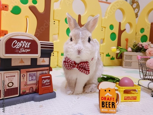 This is a bunny with a red bow on a colorful background,full of energy and fun.
The rabbit has a cute posture and soft fur. photo