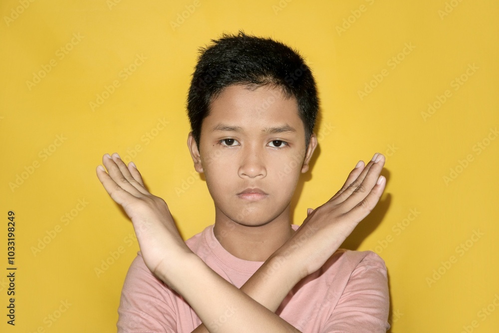 A teenager is crossing their arms. A teenager is crossing their arms.