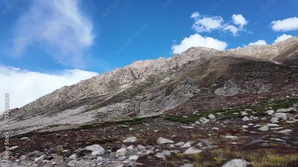 4K Mountain Majesty Side View of a Scenic Bitumen Road Winding Through Lush Green Meadows, Beneath Towering Rocky Peaks, with Building Motion Clouds, Brilliant Blue Sky,and Dramatic Light Contrast 4K Mountain Majesty Side View of a Scenic Bitumen Road Winding Through Lush Green Meadows, Beneath Towering Rocky Peaks, with Building Motion Clouds, Brilliant Blue Sky,and Dramatic Light Contrast