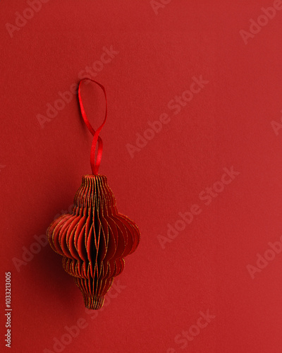 Red Christmas paper bauble as shape flashlight on red paper textured background, Scandinavian Christmas ornaments. New year paper decor, modern xmas decoration card, minimal winter holiday