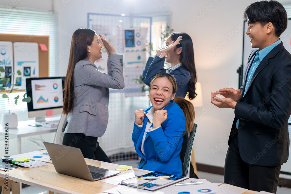 A group of people are celebrating in a business setting