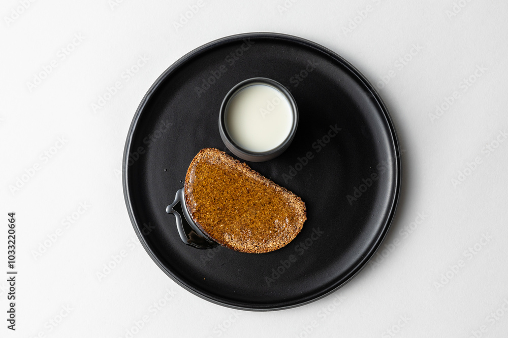 Simple Rye Bread with Honey and Milk on dark plate white background Simple Rye Bread with Honey and Milk on dark plate white background