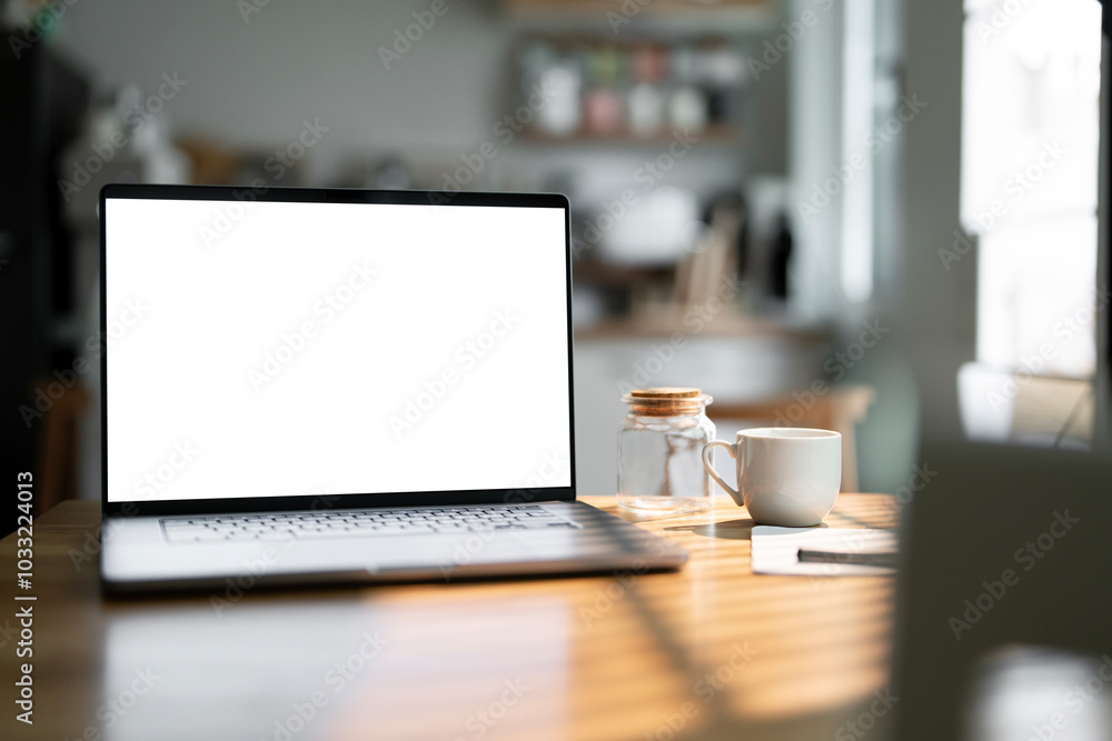 Open laptop with blank screen on a wooden desk in a kitchen room home office Open laptop with blank screen on a wooden desk in a kitchen room home office