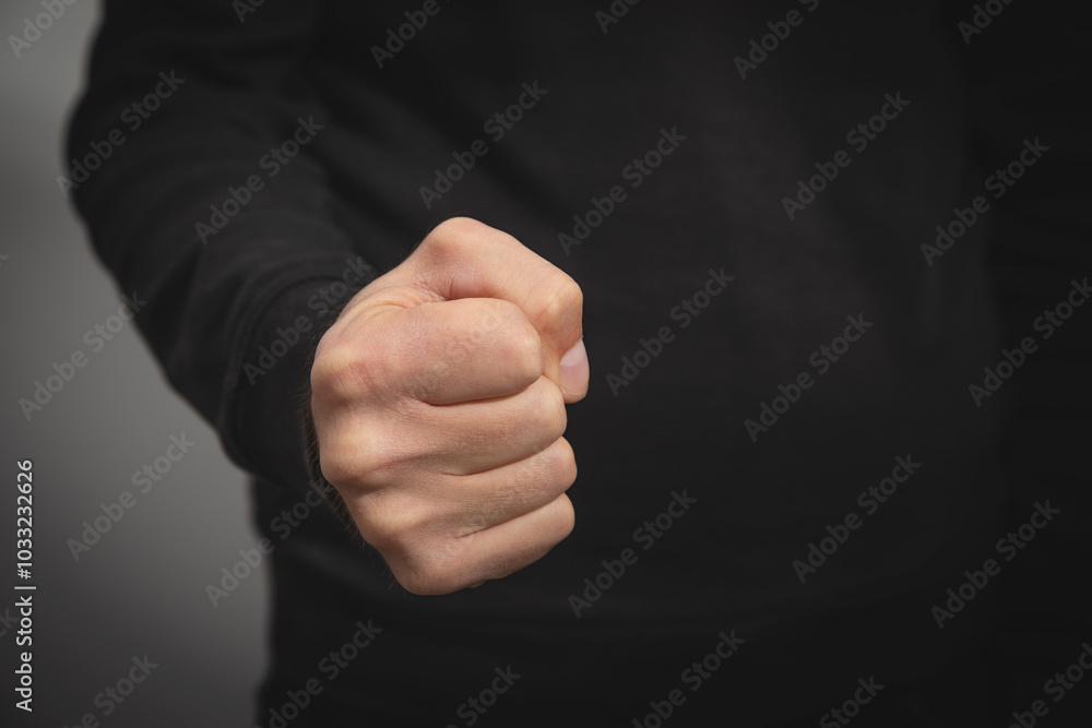 Caucasian angry and aggressive man threatening with fist.