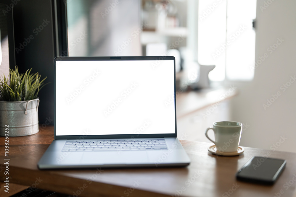 Open laptop with blank screen on a wooden desk in a kitchen room home office Open laptop with blank screen on a wooden desk in a kitchen room home office