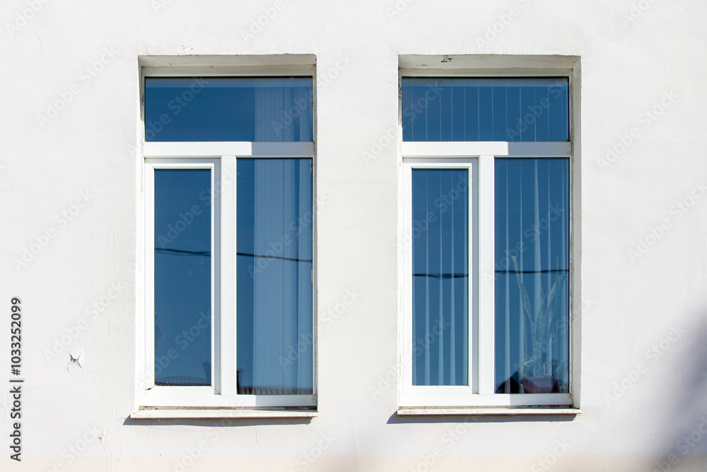 Two windows with clear glass panes and a white frame Two windows with clear glass panes and a white frame