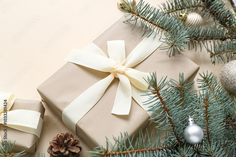 Christmas tree branches with balls and gift boxes on beige background Christmas tree branches with balls and gift boxes on beige background