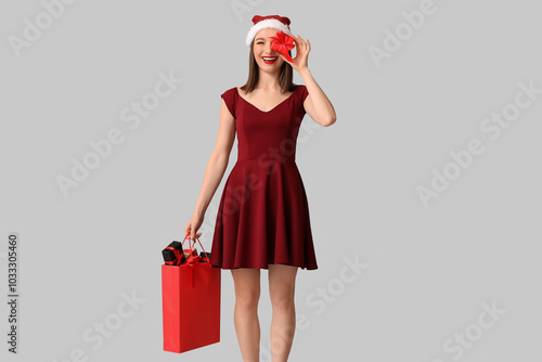 Young woman in Santa hat ho...