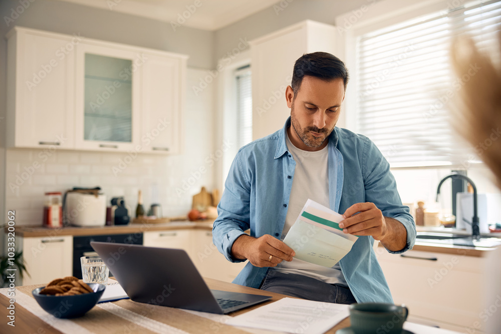 Mid adult man checking mail while working on a computer at home. Mid adult man checking mail while working on a computer at home.