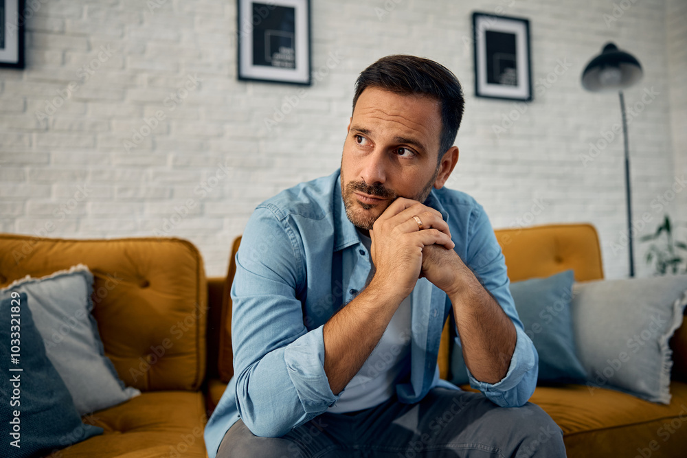 Thoughtful man sitting on sofa at home. Thoughtful man sitting on sofa at home.