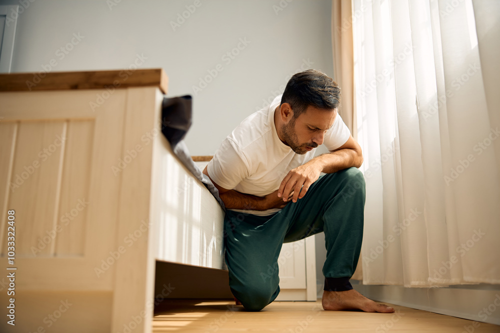 Mid adult man having stomach ache in morning. Mid adult man having stomach ache in morning.