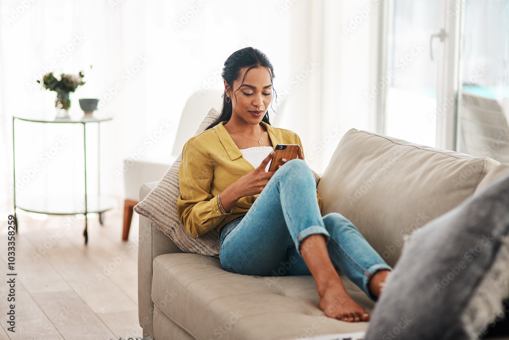 Phone, relax and wellness with woman on sofa in living room of home for break or weekend time off. App, social media and text message with African person in apartment for communication or ecommerce